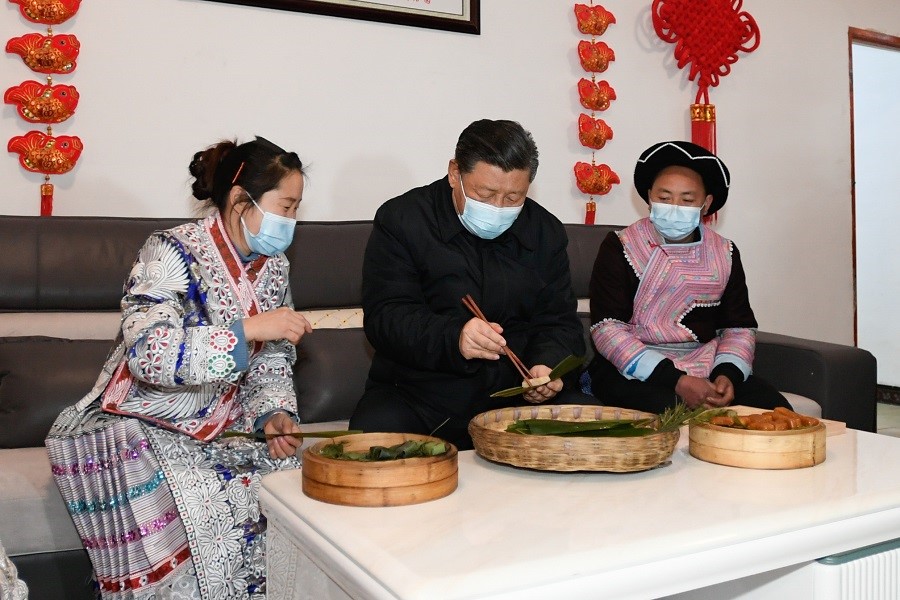 2021年2月3日下午，習(xí)近平在貴州畢節(jié)市黔西縣新仁苗族鄉(xiāng)化屋村苗族村民趙玉學(xué)家，同一家人邊聊家常邊制作當(dāng)?shù)貍鹘y(tǒng)節(jié)日食品黃粑。新華社記者 李學(xué)仁 攝